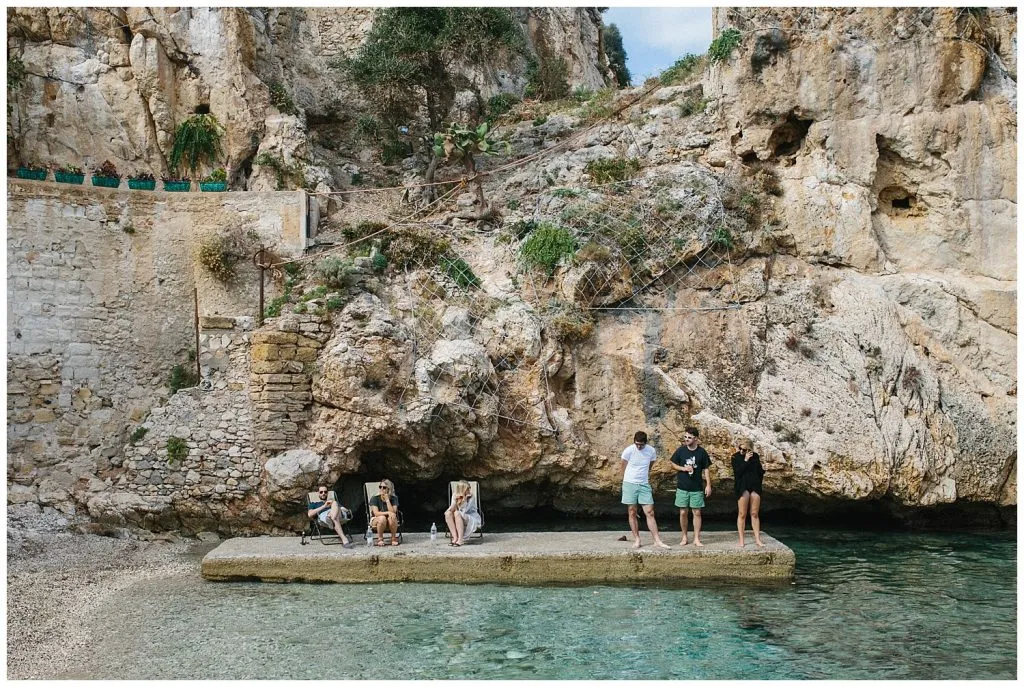 Getting married in Sicily: a group of a wedding guest enjoy the sea and relax before the ceremony in Scopello