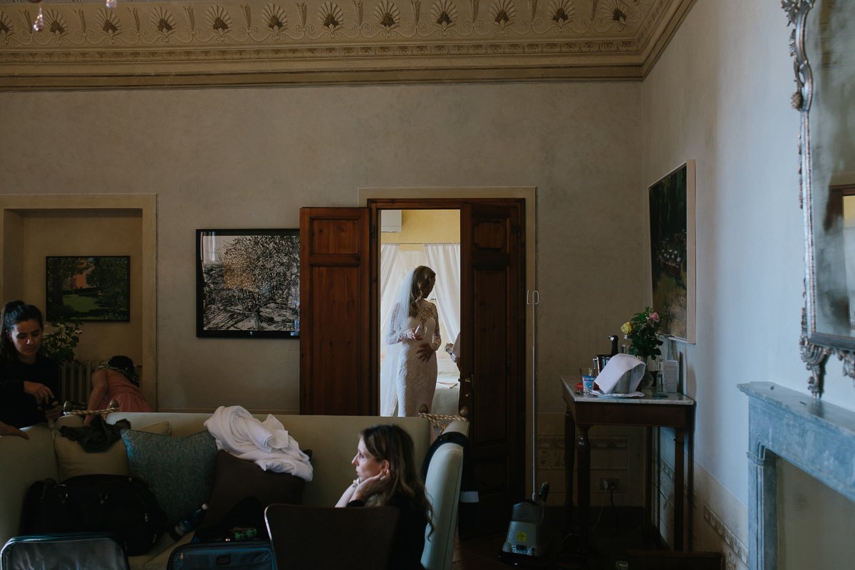 Bride getting dressed, seen through a doorway
