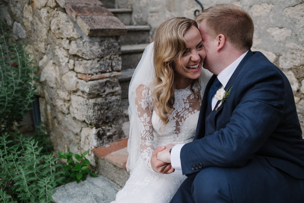 Ellie and Chad sitting on the stone steps, foreheads touching