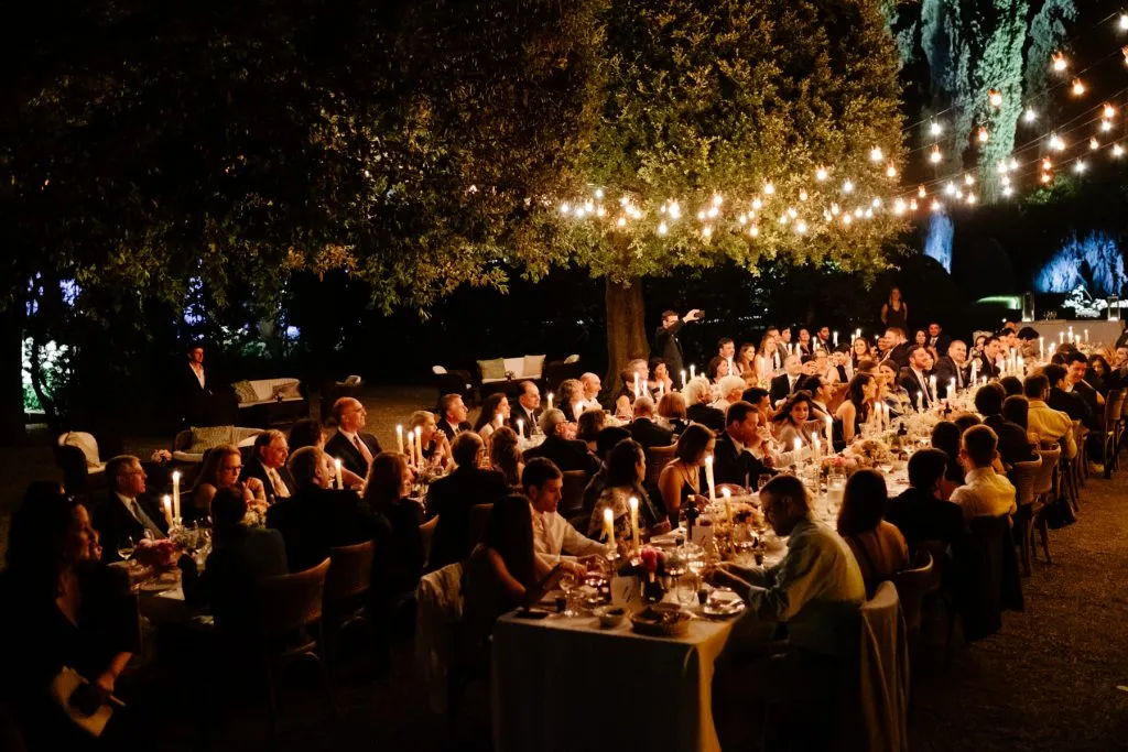 Villa La Foce wedding photography: guests are sitting under tree eating delicious italian food