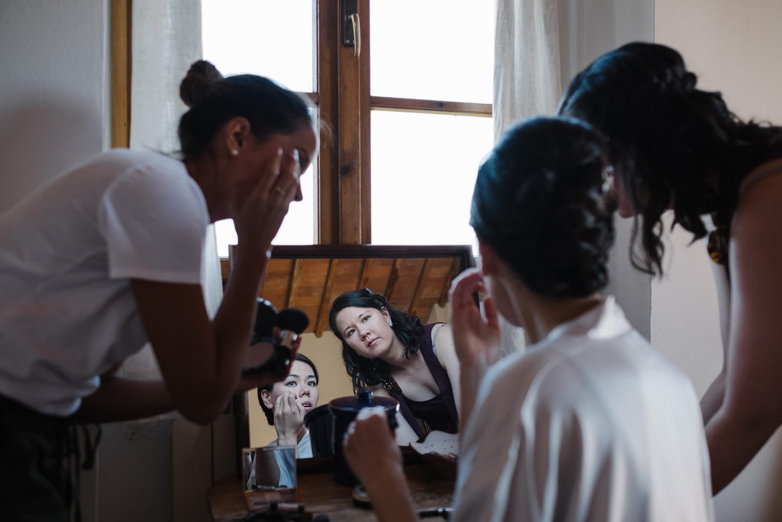 Bride laughing with friends while getting ready