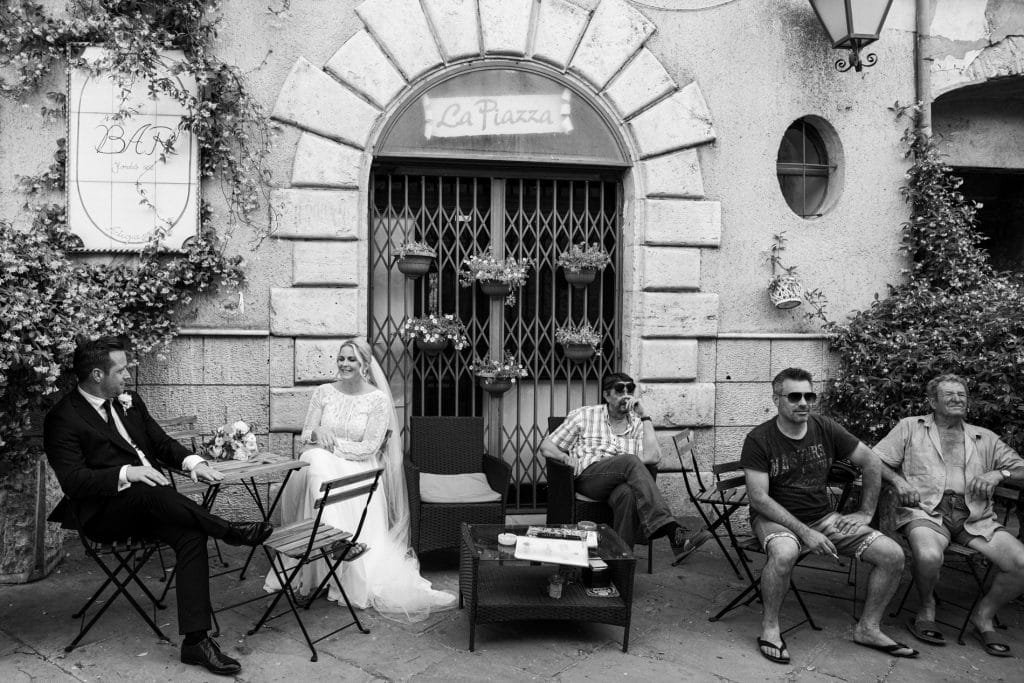 maremma wedding photographer: bride and groom sitting in an old italian bar 