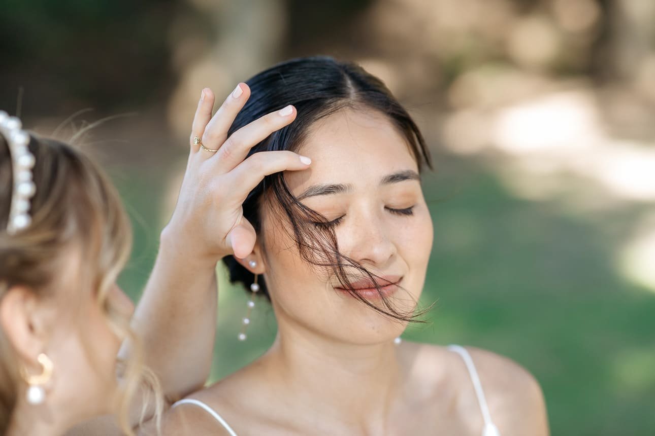 Bride fixing her hair while getting ready at the villa