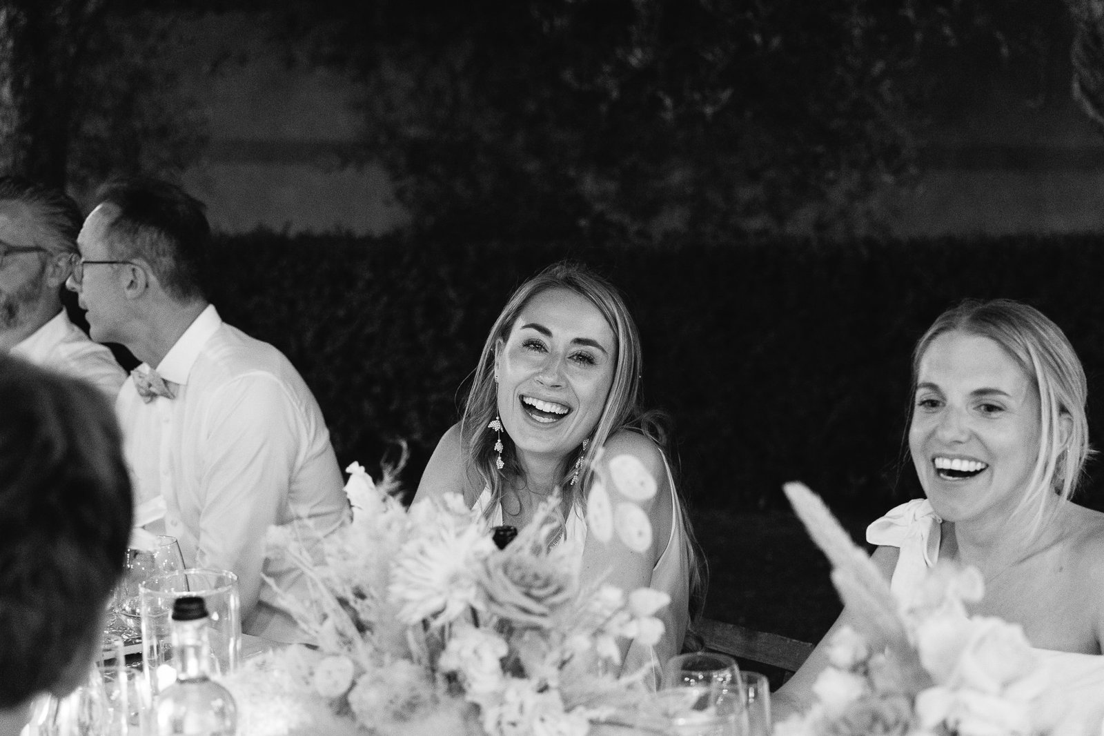 Guests laughing during the speeches, black and white