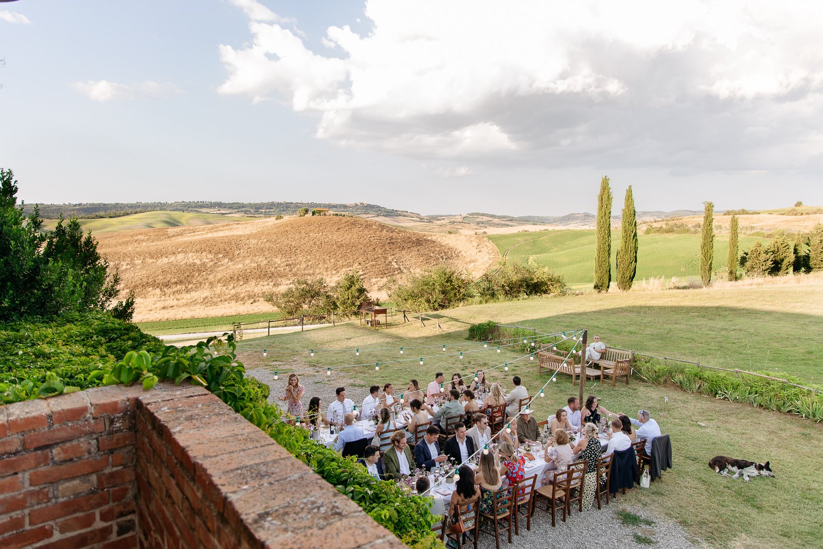 Guests at dinner on the lawn of Il Rigo, seen from the terrace