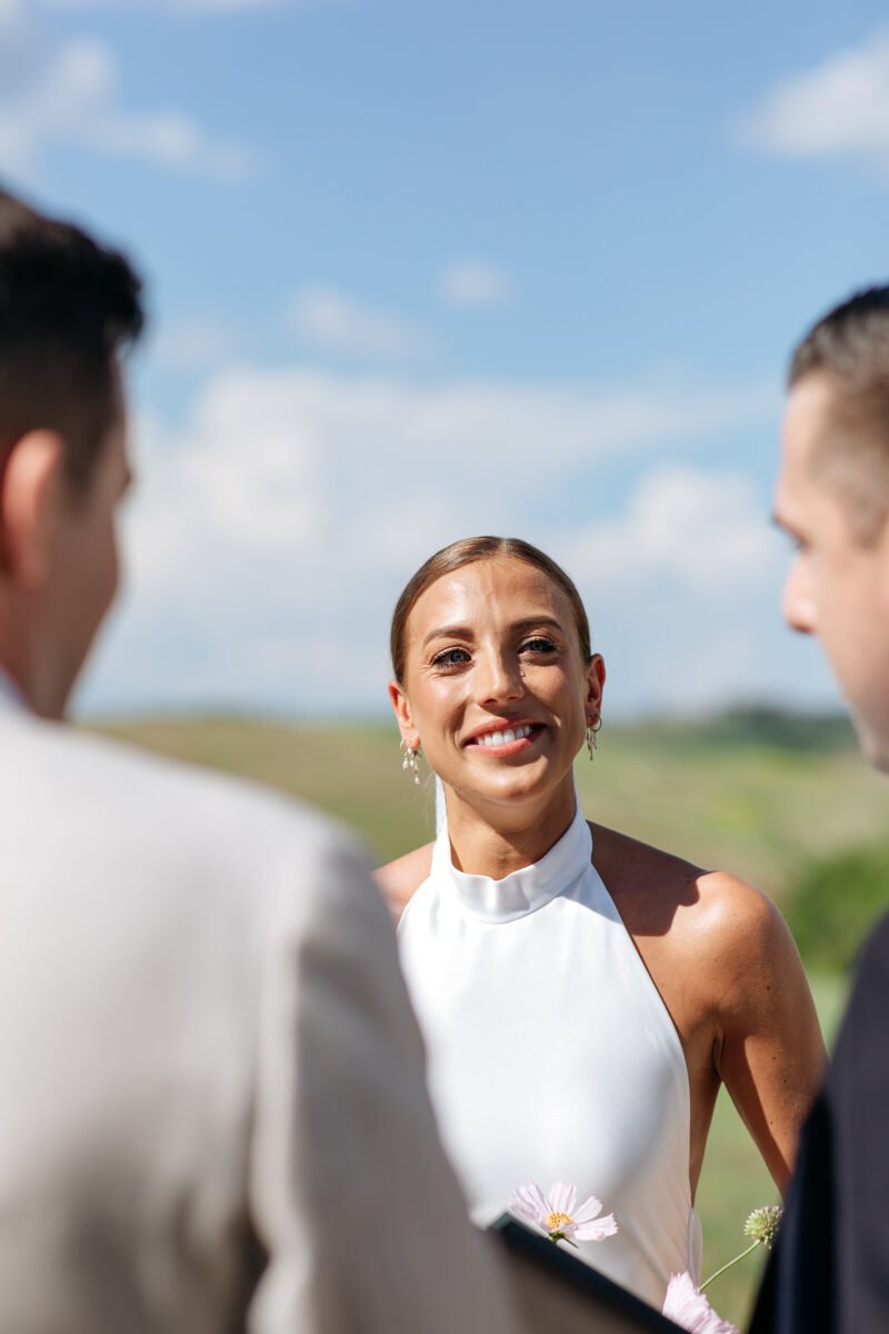 Bride smiling as she reaches the groom