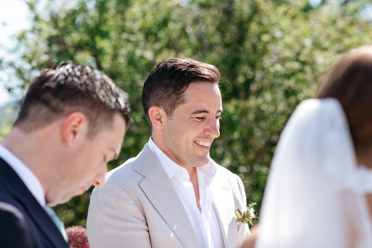 Groom smiling at the bride during the ceremony