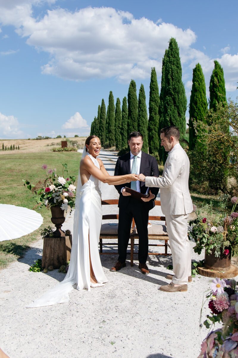 Nicole and James exchanging vows in front of the cypresses