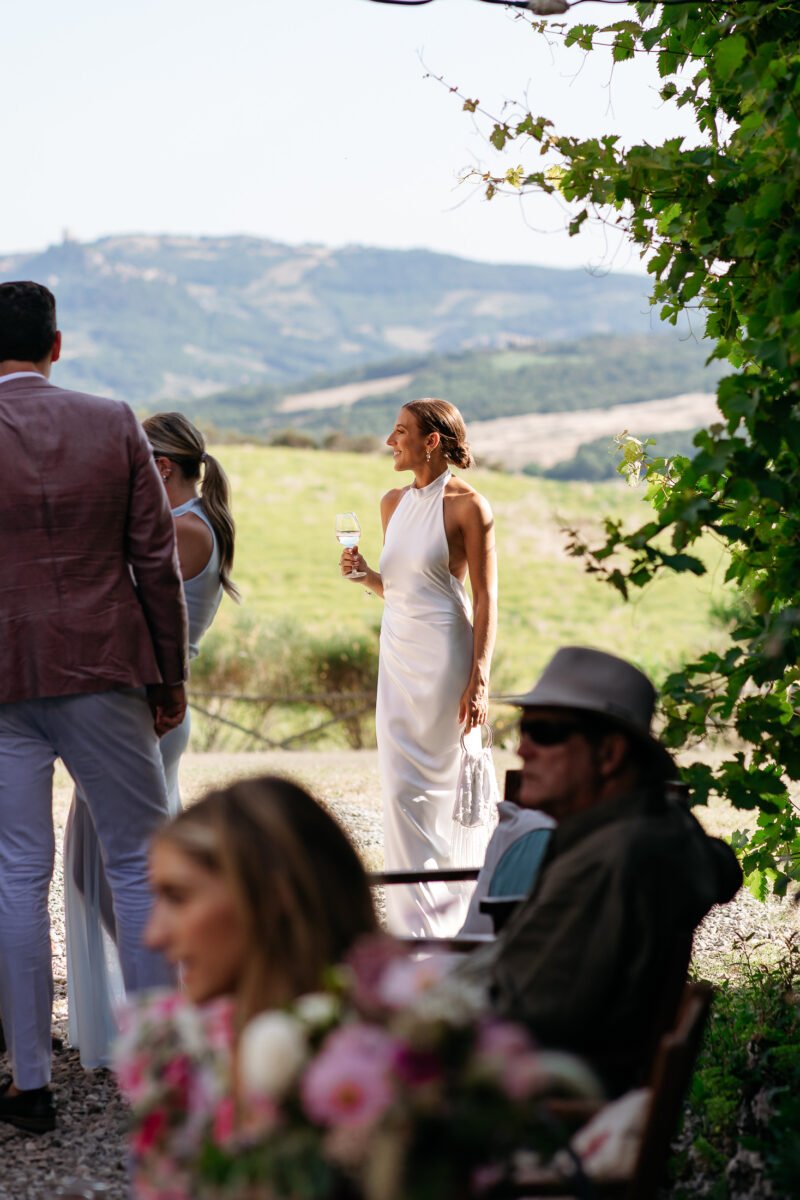 Guests chatting during the aperitivo, hills behind