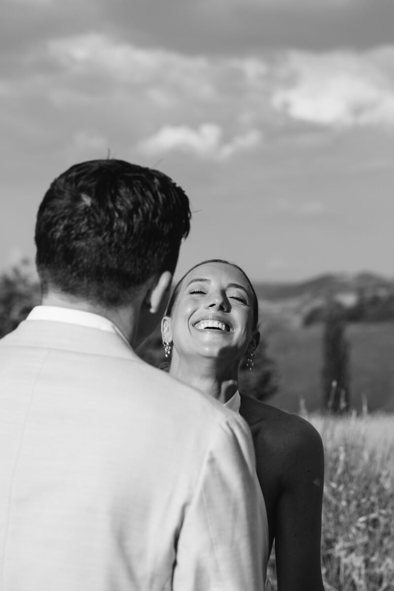 Bride and groom laughing together, black and white portrait