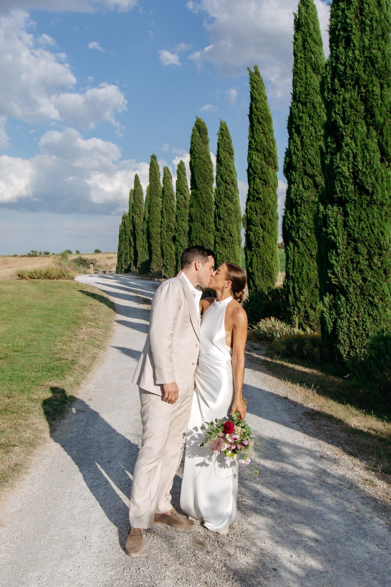Couple embracing on the cypress-lined drive