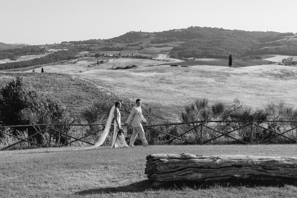 The couple small in the vast Val d'Orcia landscape, black and white