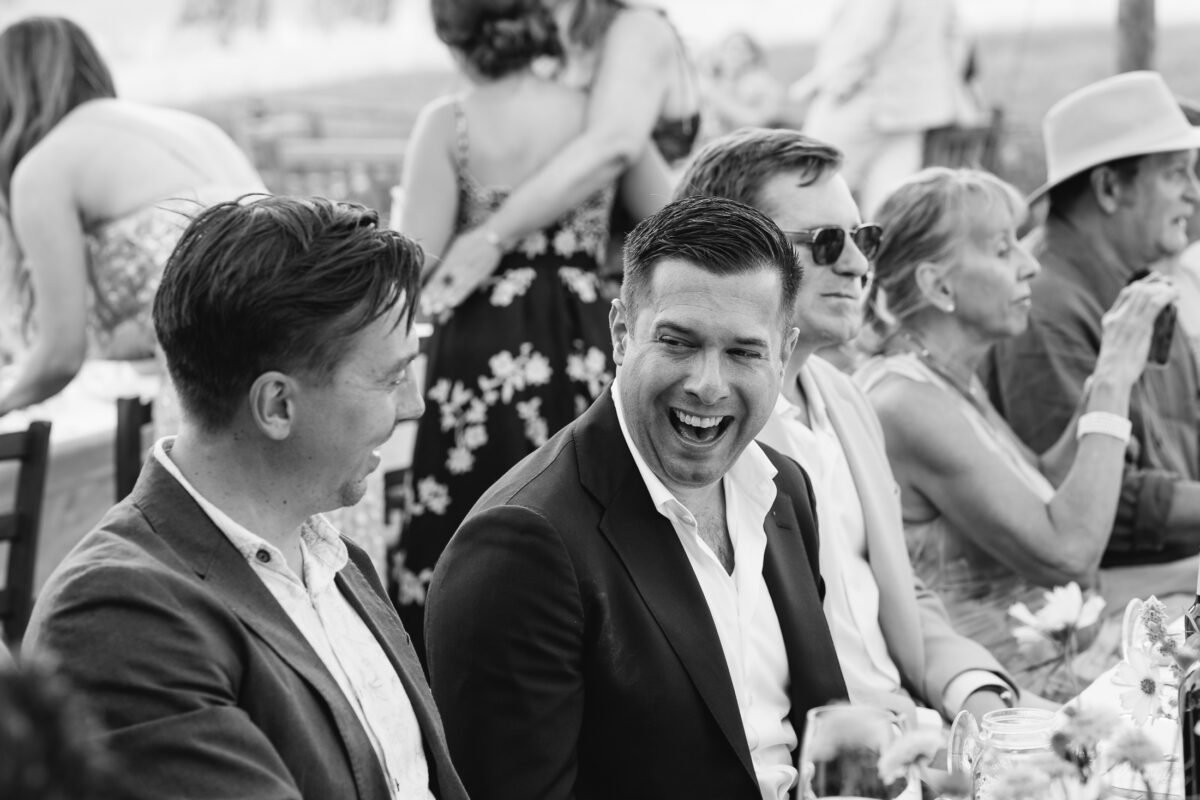 Guests laughing at dinner, black and white