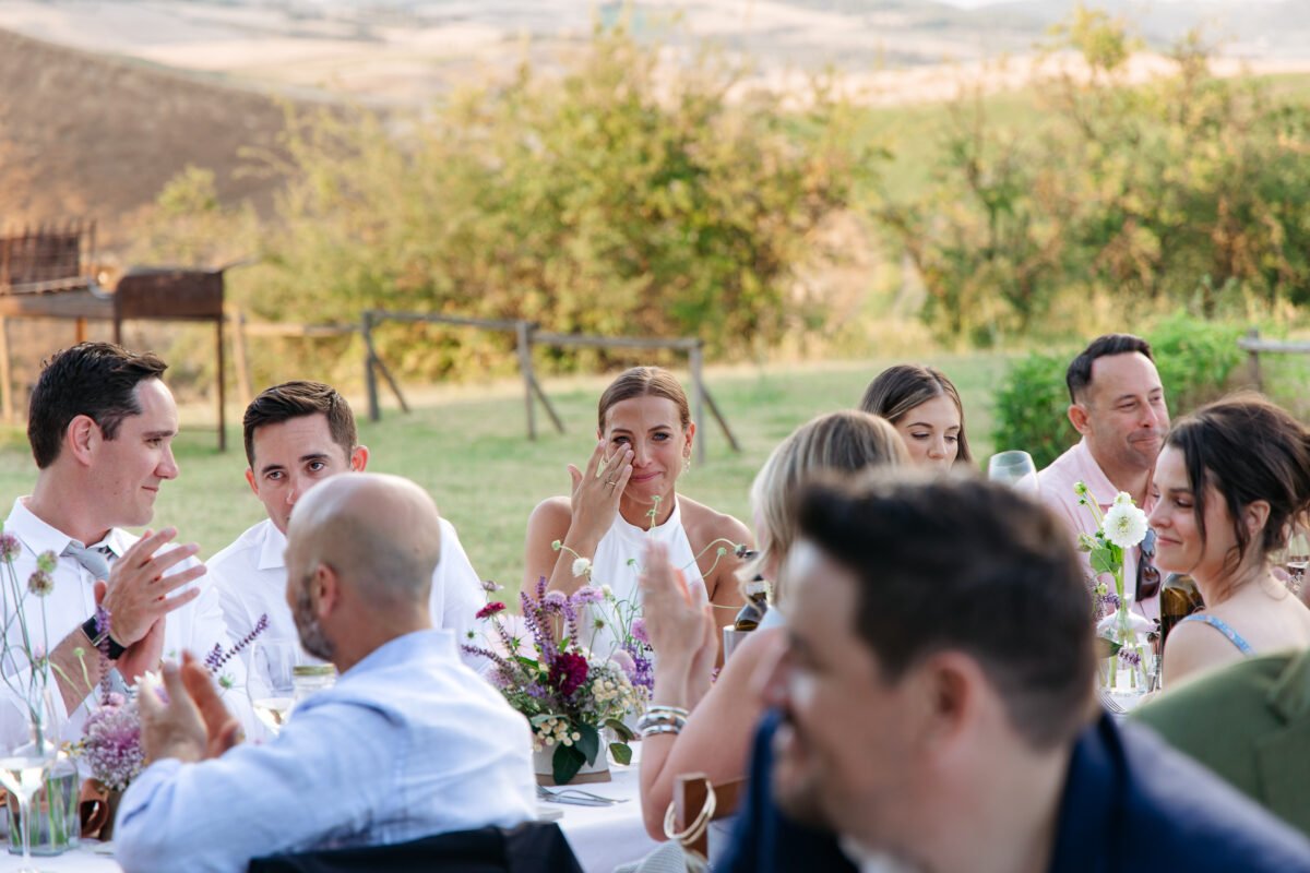 Guests at dinner on the lawn with the Tuscan hills behind