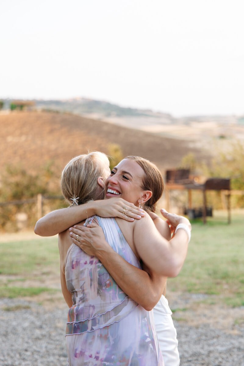 Bride hugging mom at sunset