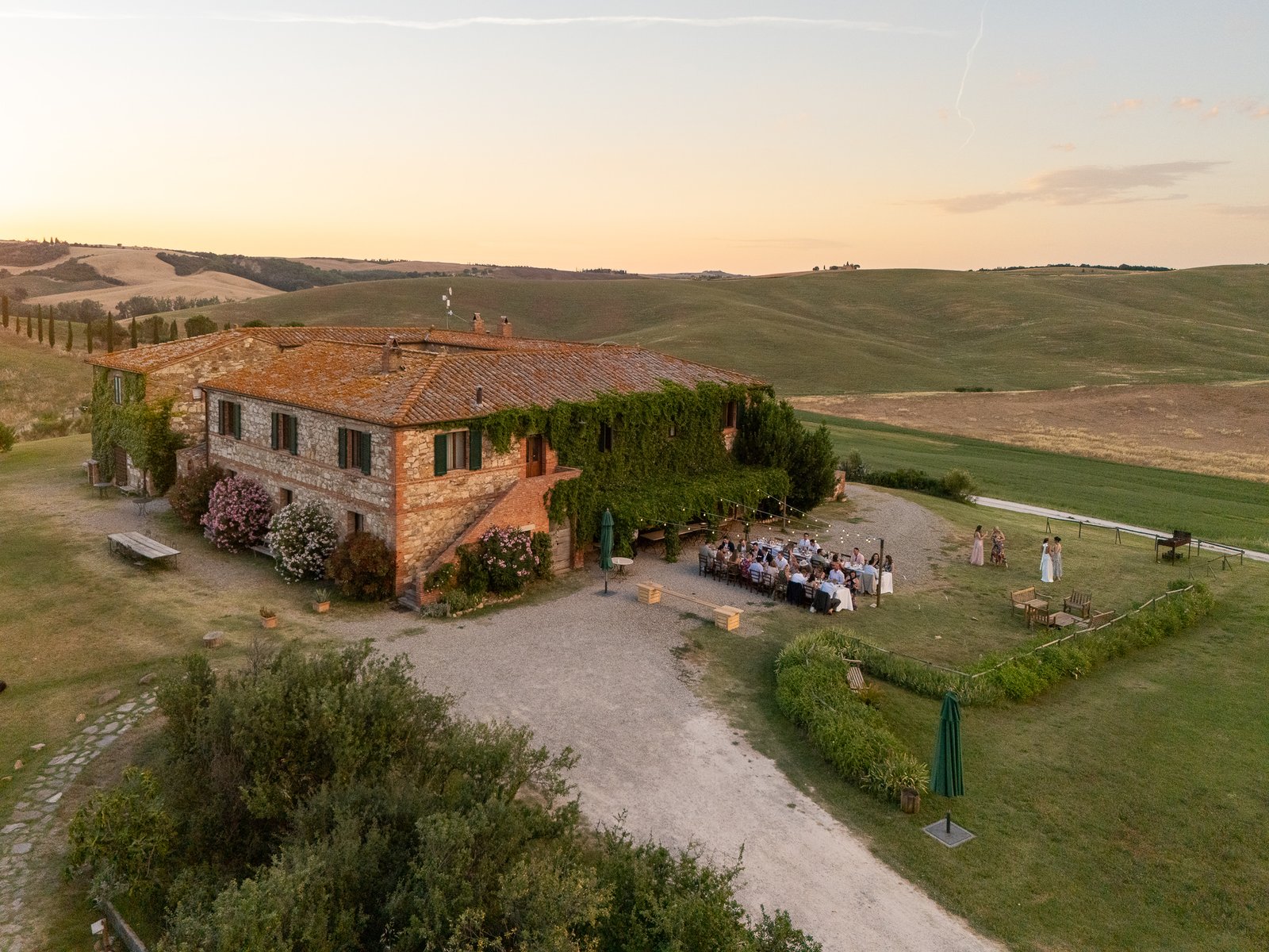 Il Rigo farmhouse among the Val d’Orcia hills at sunset, seen from above