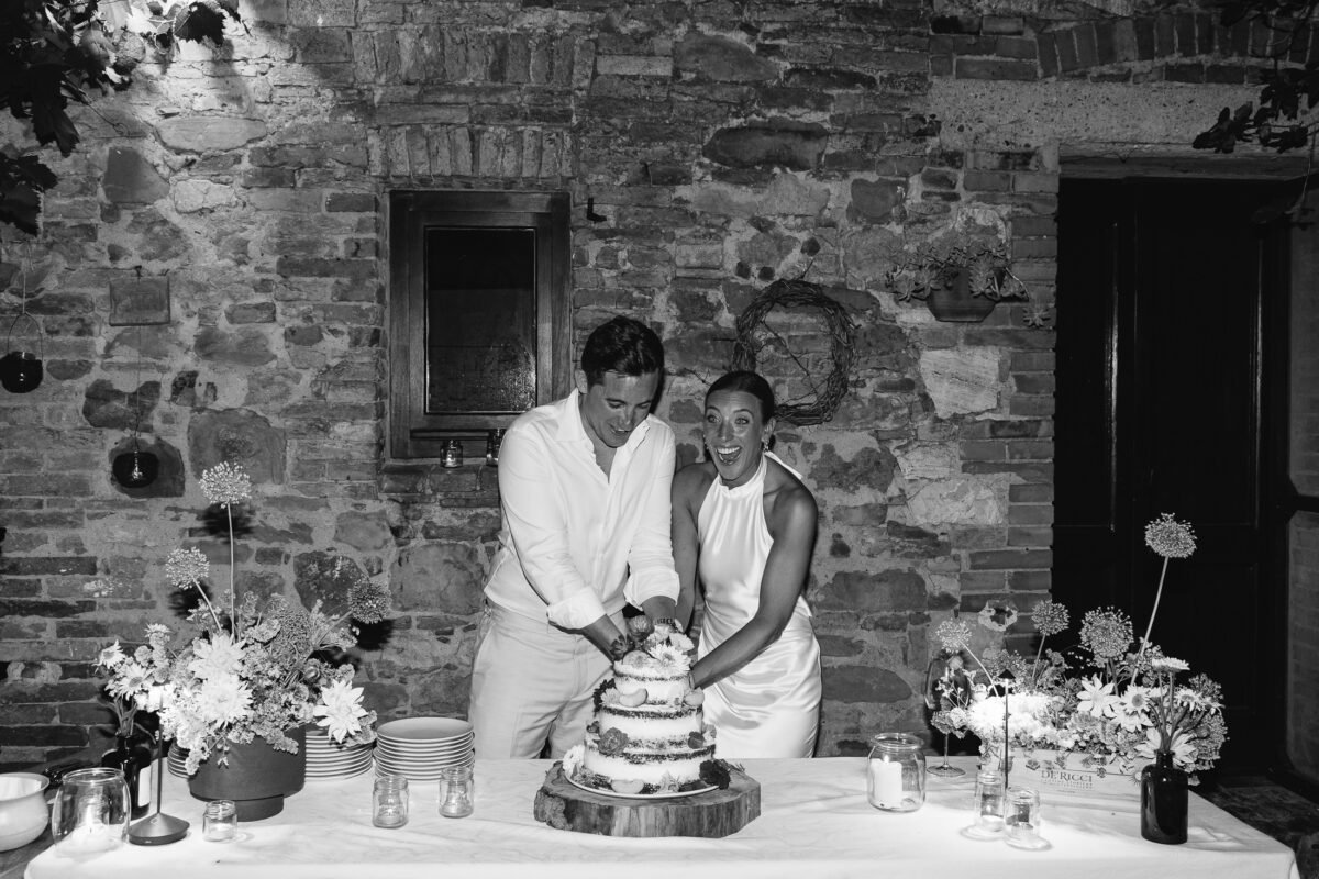 Bride and groom cutting the cake in the stone courtyard