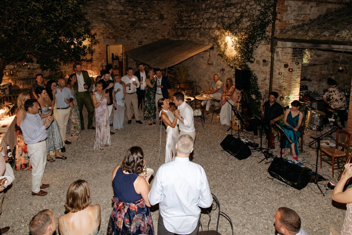 Guests watching the first dance in the lit courtyard