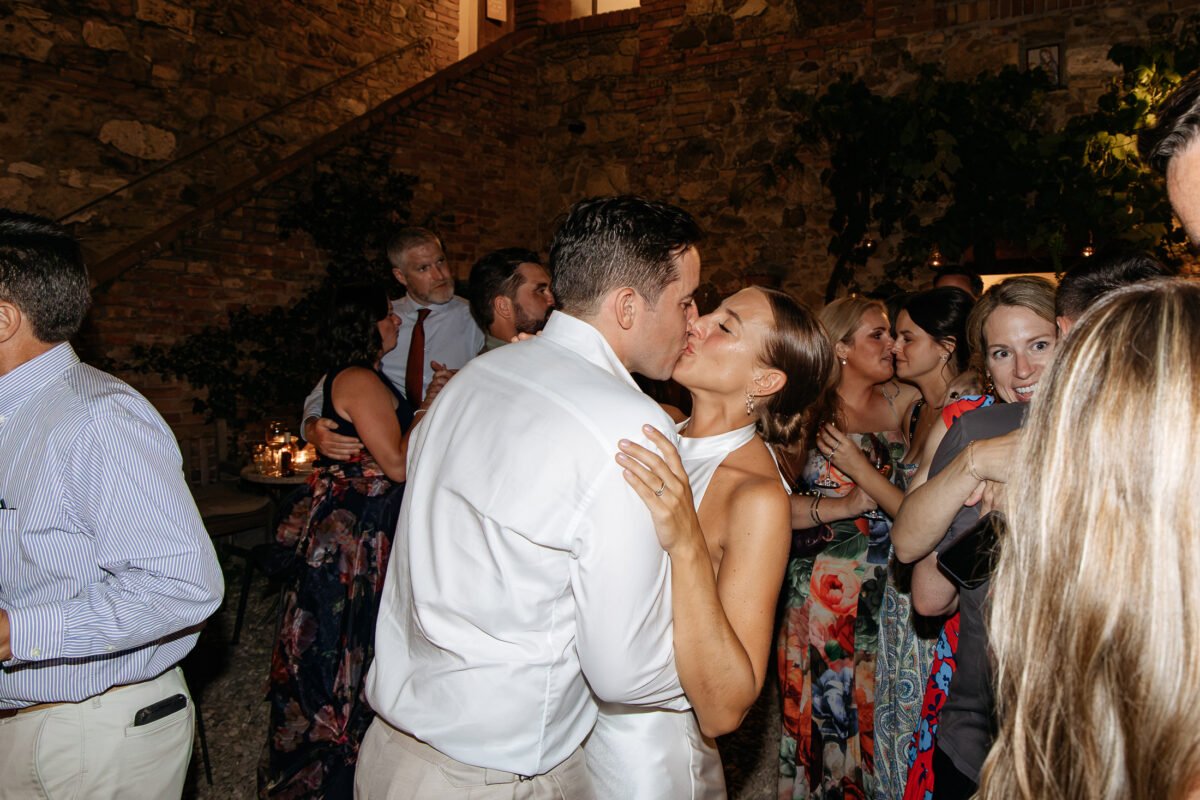 Bride and groom dancing surrounded by guests