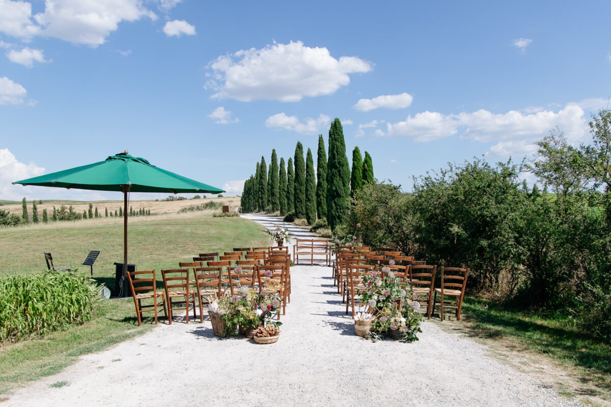 Ceremony chairs set out among the cypresses at Il Rigo