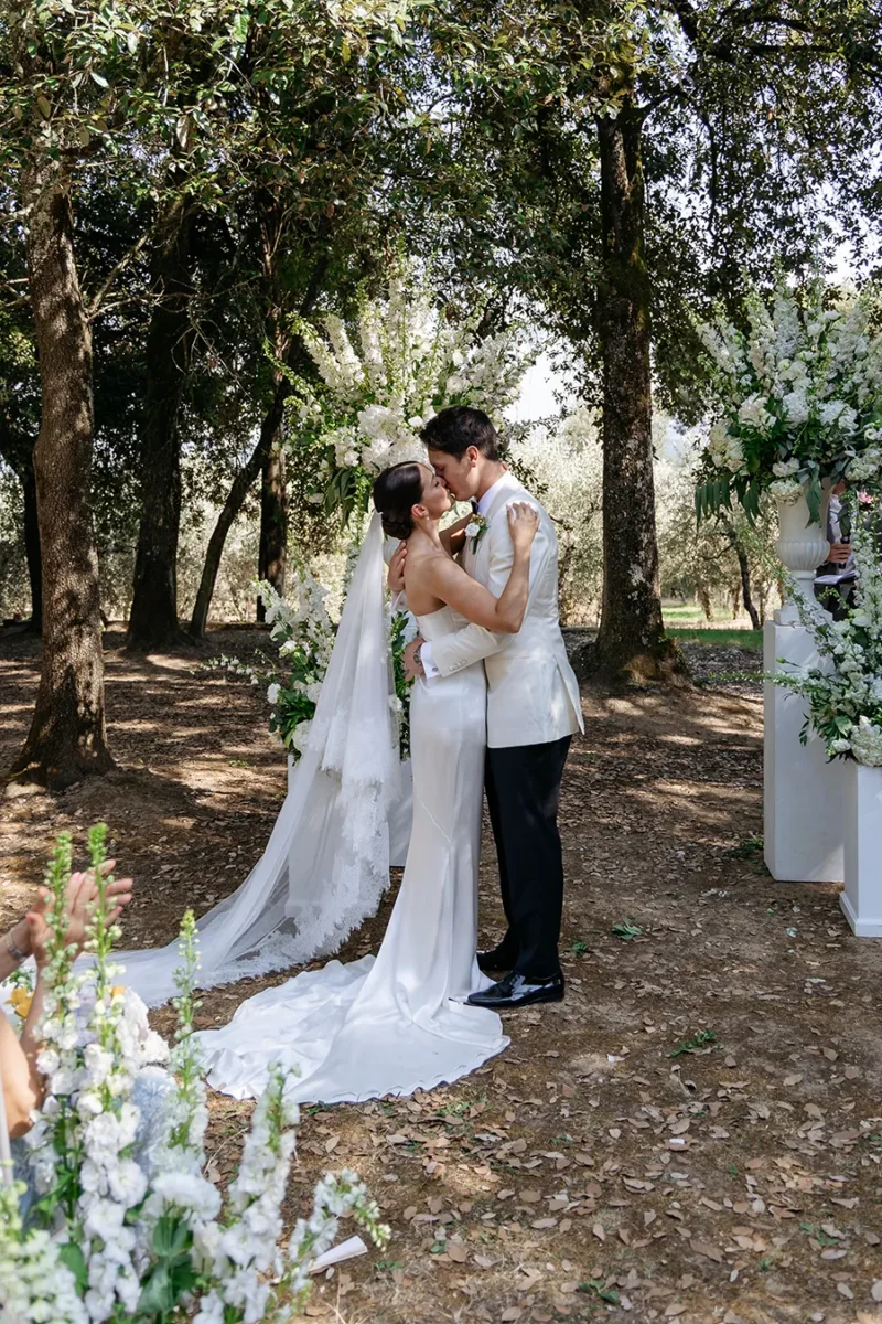 Bride and groom embracing under the trees during their couple portraits in Tuscany