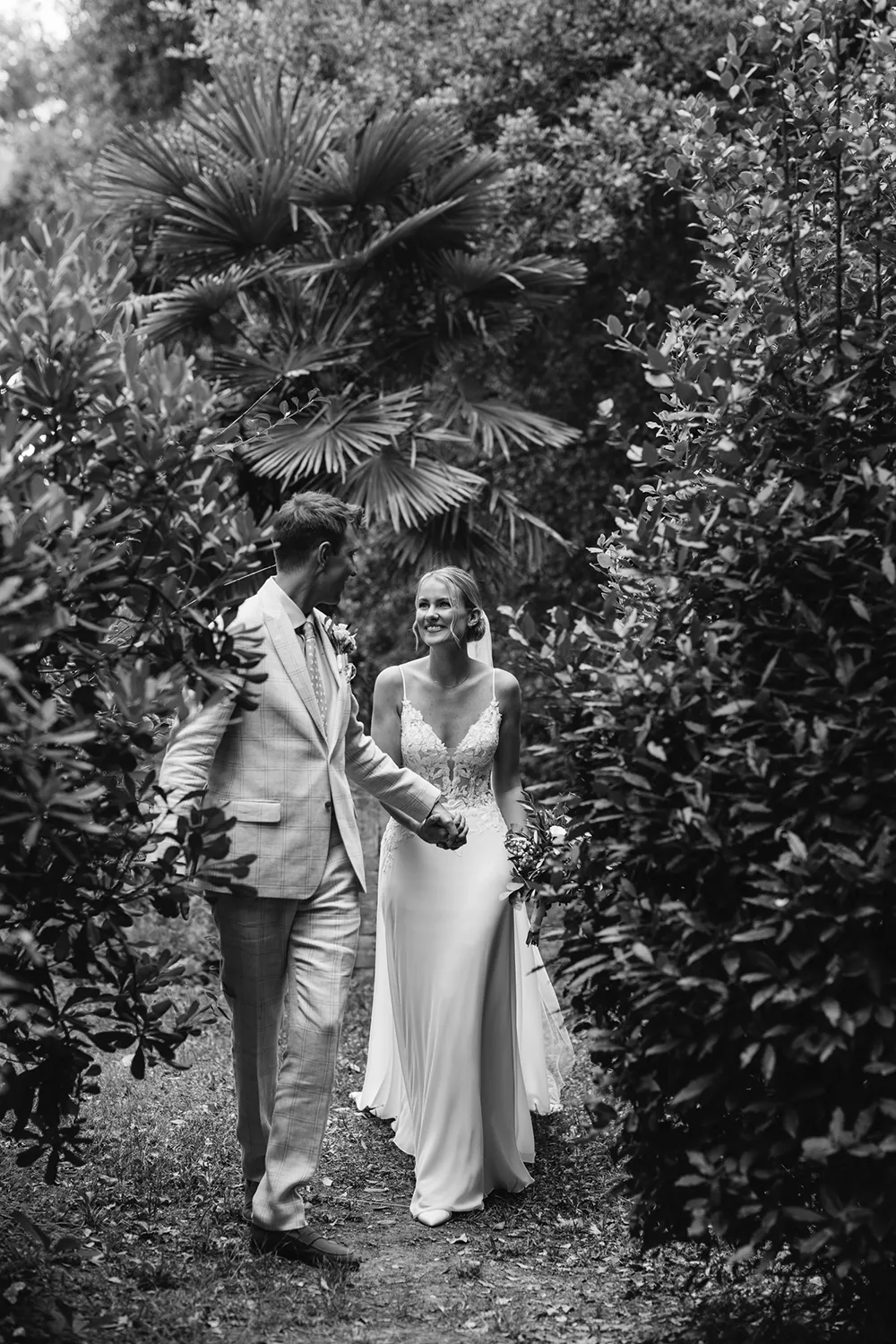 a couple is walking in the garden during a wedding portrait photography session